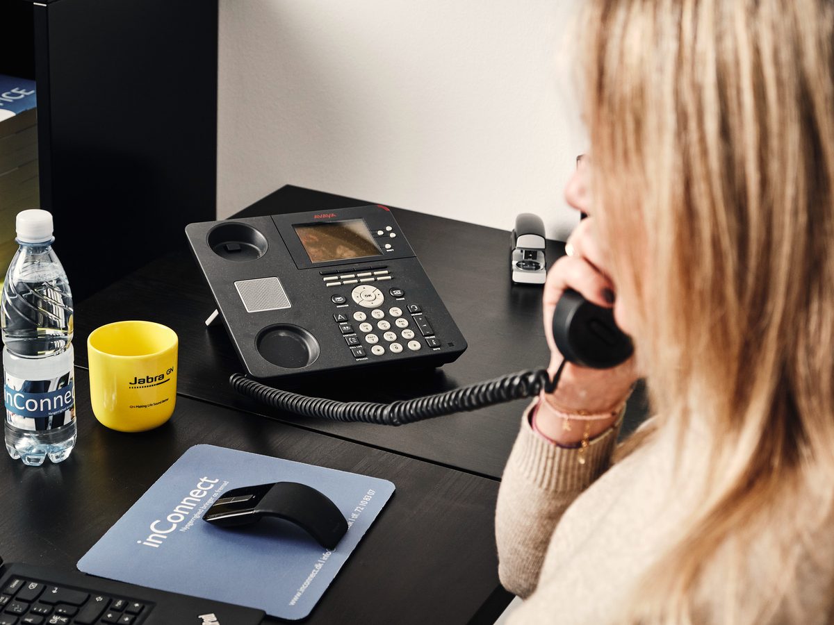 En medarbejder taler i telefon ved et skrivebord