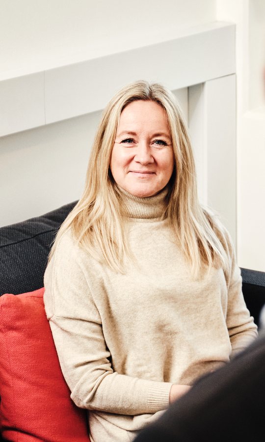 Smilende medarbejder i en sofa