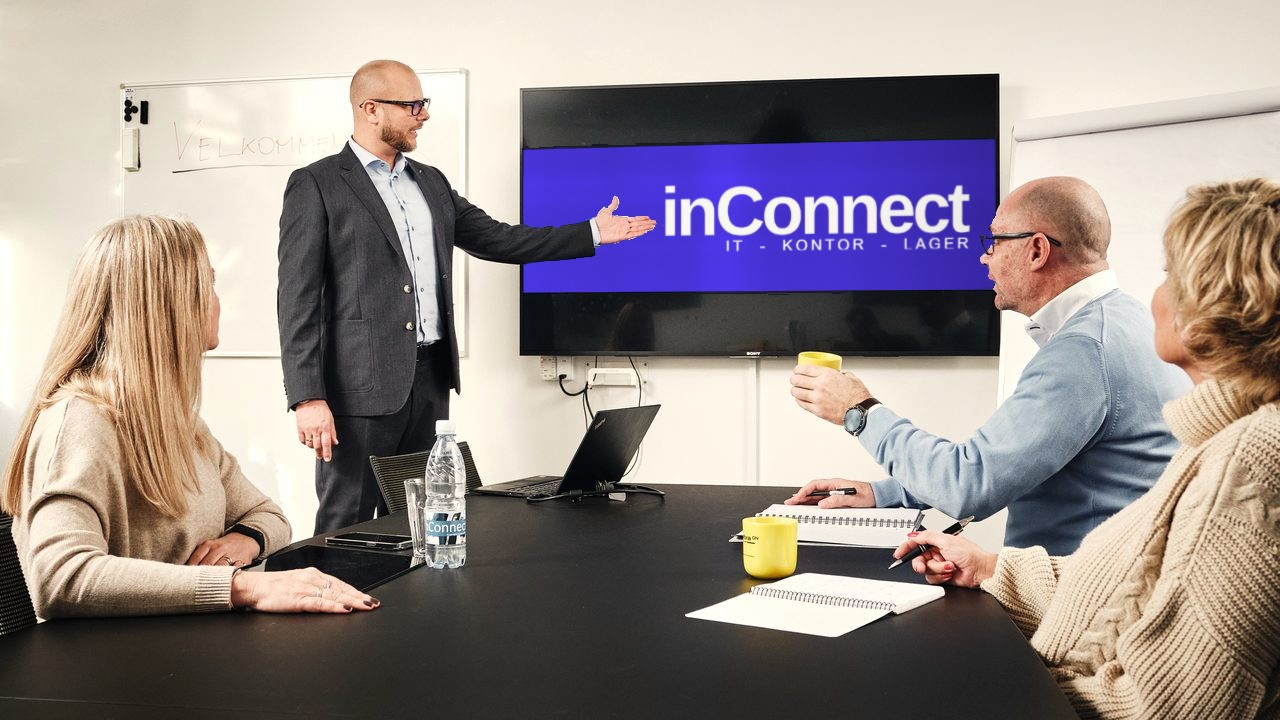 Møde i et mødelokale med inConnect-logoet på den store skærm